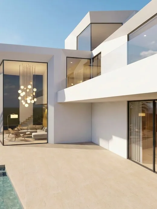 Rear terrace of the villa with an L-shaped plunge pool, a glazed corner living room, and the sea visible beyond.