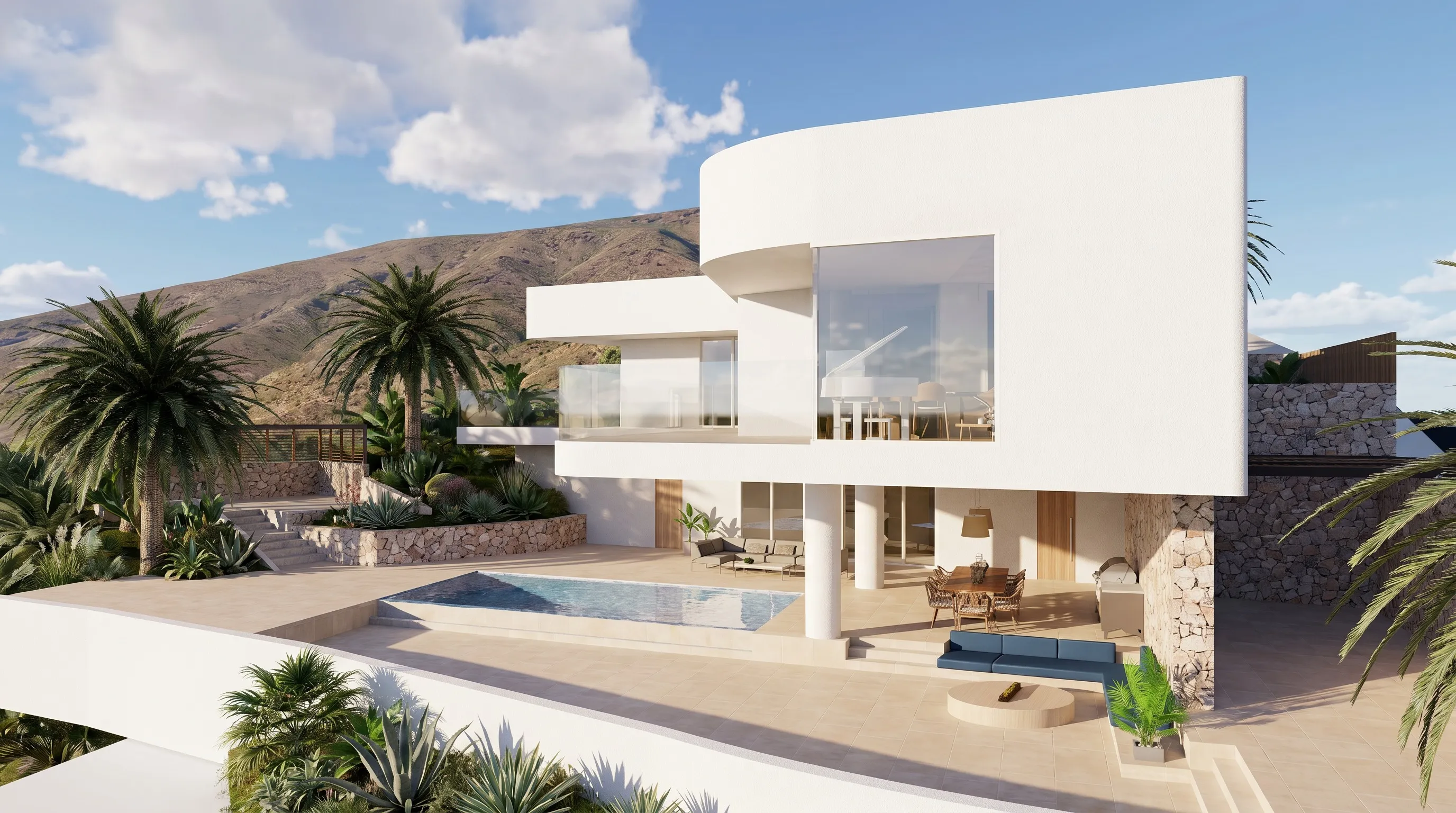 Vista aérea del volumen curvo blanco de la villa Draguito, con piscina y terraza frente a una ladera volcánica en Fuerteventura.