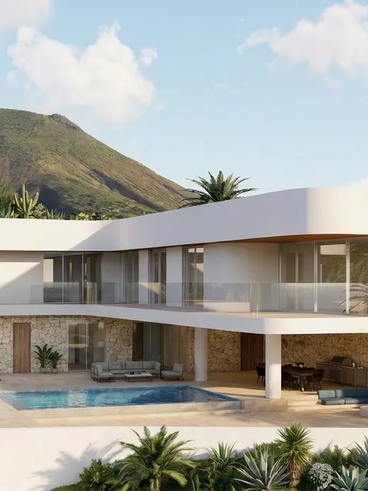Front elevation of Draguito villa with its cantilevered upper floor set against a green volcanic mountain.