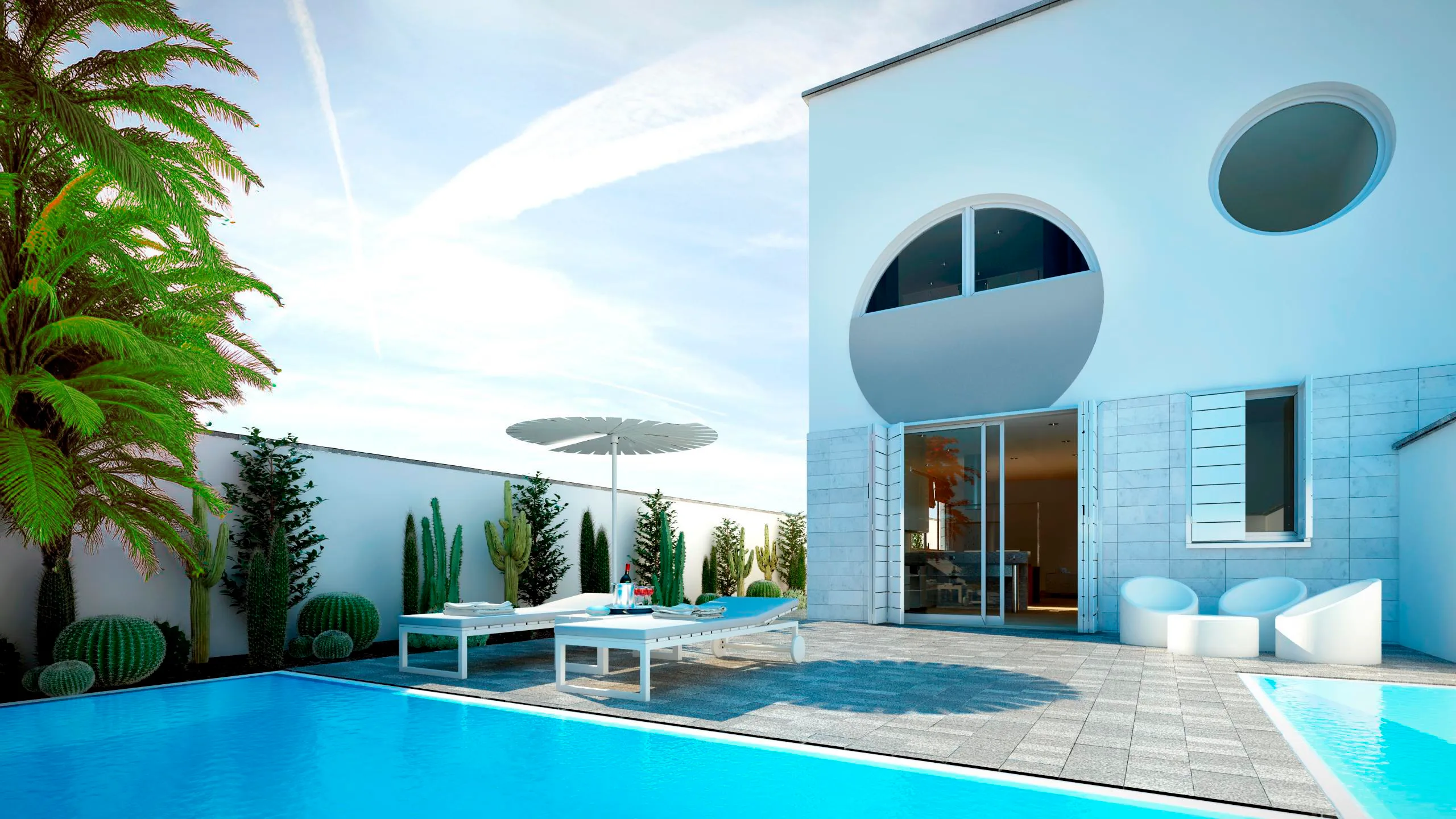 Vivienda blanca con una ventana circular tipo ojo de buey y un balcón semicircular retranqueado, junto a una piscina y un jardín de cactus y palmeras.